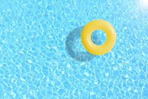 Yellow,Swimming,Pool,Ring,Float,In,Blue,Water.,Concept,Color